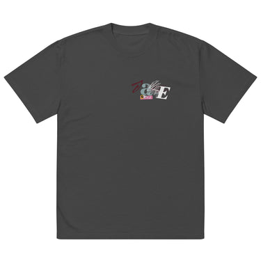Front view of a solid-colored oversized-tee. A small collage graphic on the left chest features the letters 'J' and 'E' and a serpent-like ampersand, layered over abstract shapes and sketchy lines that seemingly cover the letters ‘A’ and ‘N’ to form “Jane”.