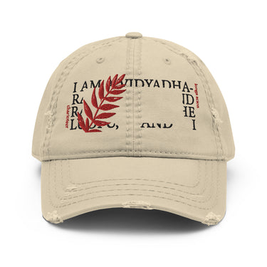 Distressed khaki baseball cap on a white background. The front features an embroidered design with a block of fragmented text in a black, classical-style font. A large, vertical red fern leaf is embroidered over the left side of the text. Small, vertical red text reading "charioteer" and "longs scion" frames the central design.