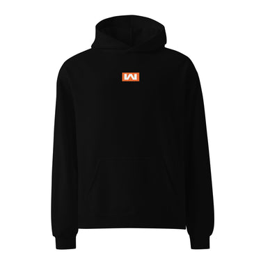 Black oversized hoodie, front view, featuring a small centered orange rectangular logo with a stylized white 'M' inside.