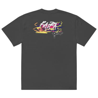 Back view of a solid-colored oversized-tee. A large, horizontal graphic on the upper back features a stylized, graffiti-like word spelling “RAPPA” layered over a wide smear of high-contrast brush strokes imitating graffiti splatter. To the side are smaller, schematic graphics including a compass rose and blocks of text.