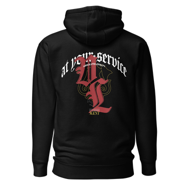 Back view of a solid-colored hoodie. A large, ornate graphic on the upper back features the text "at your service" arched over a large, high-contrast gothic monogram. The design is embellished with fine-line scrollwork and 3d lettering of V and L in blackletter font.