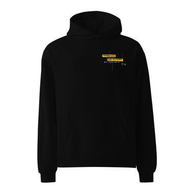 Front view of an oversized hoodie in black. Design is positioned on the upper left chest. Design features a yellow rectangular label reading “CONNECKEN,” smaller text “DER WÄCHTER,” and fine white script lines and coordinates below it.