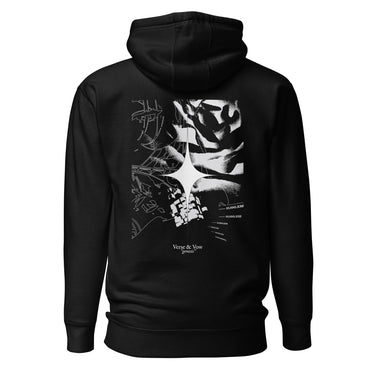 Back view of an hoodie in black. The design showcases a large, intricate graphic centered on the upper back. A radiant, four-point star form sits in the middle, surrounded by fragmented abstract shapes, and faint technical linework. Scattered numbers and coordinates appear along the right side, adding a coded, data-driven atmosphere. At the bottom of the composition, serif text reads “Verse & Vow,” followed by the word “genesis” in delicate handwritten script.