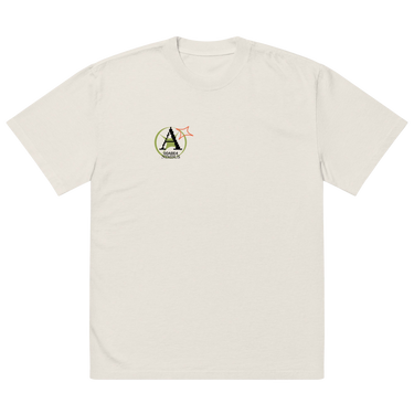 Front view of a solid-colored oversized-tee. A small graphic on the left chest features a circular emblem containing a large, pixel-art style letter 'A'. A small, outlined star symbol is next to the emblem.