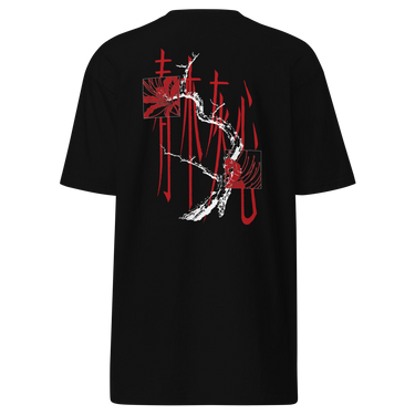 Back view of a tee in black. Four large vermillion brushstroke characters reading "春木灰心" run vertically down the center, layered with a stark white-and-red painterly tree branch winding through them. Two crimson rectangles bracket smaller ink motifs in the upper-left and lower-right, giving the composition an expressive, calligraphic, graphic-forward feel.