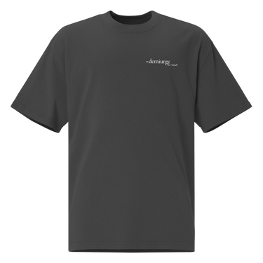 Front view of an oversized tee in black. Design features a small, minimal text print placed on the upper left chest. The word “demiurge” appears in a clean serif font, preceded by a small infinity-shaped symbol. Just beneath it, in tiny handwritten script, the phrase “the mind” is printed in quotation marks.