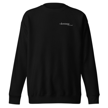 Front view of an sweatshirt in black. Design features a small, minimal text print placed on the upper left chest. The word “demiurge” appears in a clean serif font, preceded by a small infinity-shaped symbol. Just beneath it, in tiny handwritten script, the phrase “the mind” is printed in quotation marks.