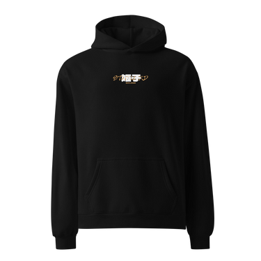 Front view of a Oversized Hoodie in Black. a small chest graphic pairing a gold cursive wordmark partially overlaid by a bold white stylized emblem, with a block-letter word underneath in the same gold tone