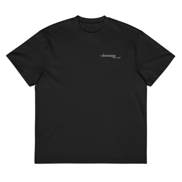 Front view of a box tee in black, flat. Design features a small, minimal text print placed on the upper left chest. The word “demiurge” appears in a clean serif font, preceded by a small infinity-shaped symbol. Just beneath it, in tiny handwritten script, the phrase “the mind” is printed in quotation marks.