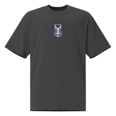 The front of a faded black oversized t-shirt. Centered on the chest is a small graphic featuring a stylized white symbol, resembling a chalice, set against a blue rectangular background.
