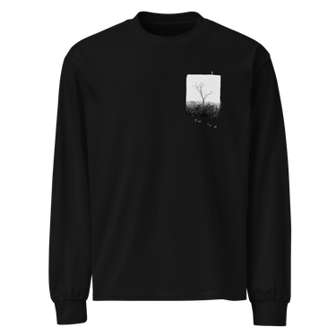 Front view of a longsleeve in black. A small halftoned panel sits on the left chest: a bare, leafless tree standing over dark undergrowth, printed with a woven fabric texture and rough torn edges. Below it the words "pas seul" are set in a fine serif, the letters scattered and stepping down to the right.