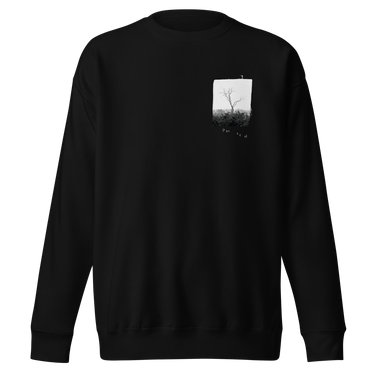 Front view of a sweatshirt in black. A small halftoned panel sits on the left chest: a bare, leafless tree standing over dark undergrowth, printed with a woven fabric texture and rough torn edges. Below it the words "pas seul" are set in a fine serif, the letters scattered and stepping down to the right.