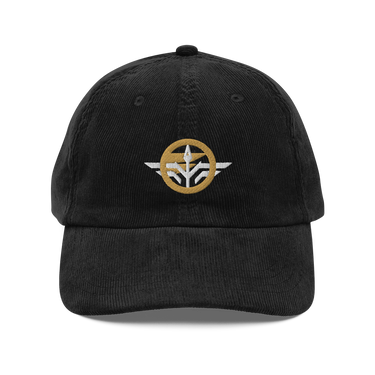 Front view of a corduroy cap in Black. A circular emblem is embroidered on the front panel: a plain gold ring, with a white winged spearhead stitched through its centre and swept wings running out to either side. Unstructured six-panel corduroy crown, curved brim, metal buckle.