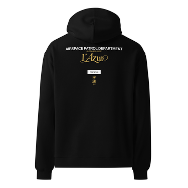 Back view of an oversized hoodie in Black. A stacked graphic fills the upper back: "AIRSPACE PATROL DEPARTMENT" in heavy white capitals, "GLORIA NOS DUCIT" in smaller gold capitals beneath it, then "L'Azur" in a large gold script with a long trailing flourish. Below sit a small white box lettered "FIRST SPEAR" in black, a weathered gold seal stamp carrying two characters, and "gen 5" in gold.