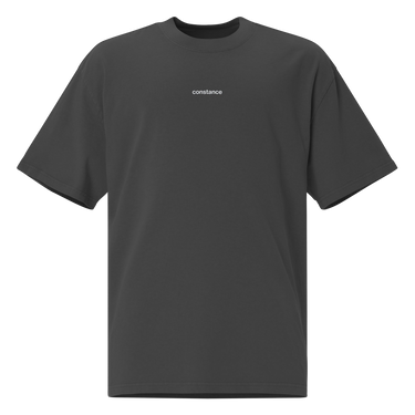 Front view of an oversized tee in black. Minimal design featuring a small white lowercase word “constance” centered across the upper chest. The typography is clean and modern, standing out subtly against the solid black fabric.