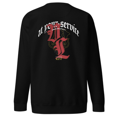 Back view of a solid-colored sweatshirt. A large, ornate graphic on the upper back features the text "at your service" arched over a large, high-contrast gothic monogram. The design is embellished with fine-line scrollwork and 3d lettering of V and L in blackletter font.