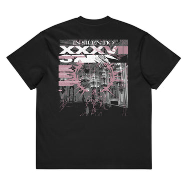 Back view of a box tee in black. A large rectangular back graphic layers an ornate hall interior in high-contrast greyscale beneath oversized roman numerals 'XXXVII' and a serif 'IN SILENTIO' wordmark. Dusty pink text bars carry a short poem down the left edge, cut through by thorned starburst linework in the same pink.