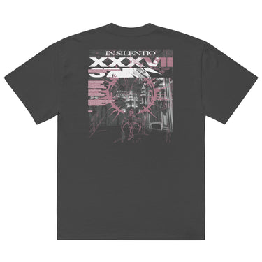 Back view of an oversized tee in faded black. A large rectangular back graphic layers an ornate hall interior in high-contrast greyscale beneath oversized roman numerals 'XXXVII' and a serif 'IN SILENTIO' wordmark. Dusty pink text bars carry a short poem down the left edge, cut through by thorned starburst linework in the same pink.