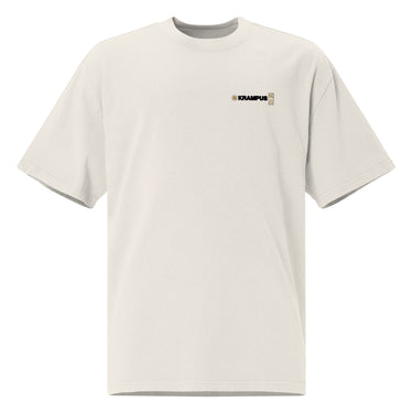 Front view of an oversized tee in faded bone. A minimalist design placed on the upper left chest shows a compact arrangement of small graphic elements, including a circular icon, the word “KRAMPUS” in bold, and a narrow vertical block with stylized symbols.