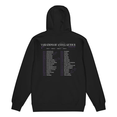 Back view of a zip hoodie in black. A large graphic fills the upper back, laid out like a concert tour poster. A wide display serif title reads "VARIATIONS OF A STELLAR TOUR" in white, with a small italic "robin" and "/summeretto" tucked beneath it and a ruled row of four era markers below that. Two columns of dated stops run down the rest in condensed capitals, the dates set in violet, with thin outlined starbursts drifting across the list.