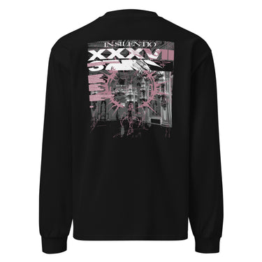 Back view of a longsleeve in black. A large rectangular back graphic layers an ornate hall interior in high-contrast greyscale beneath oversized roman numerals 'XXXVII' and a serif 'IN SILENTIO' wordmark. Dusty pink text bars carry a short poem down the left edge, cut through by thorned starburst linework in the same pink.