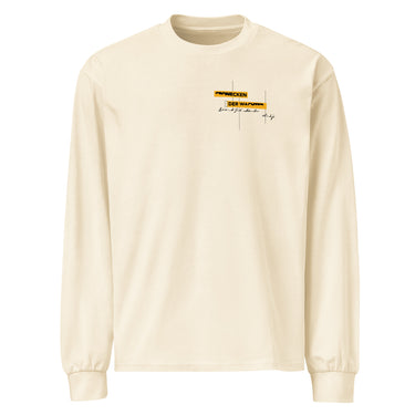 Front view of an longsleeve in beige. Design is positioned on the upper left chest. Design features a yellow rectangular label reading “CONNECKEN,” smaller text “DER WÄCHTER,” and fine white script lines and coordinates below it.