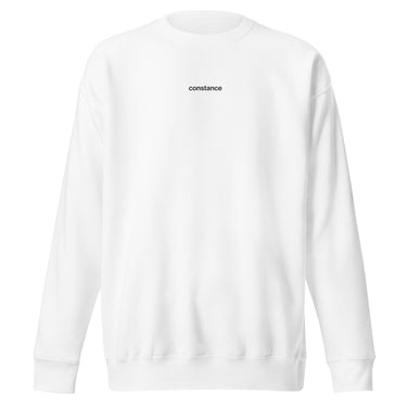 Front view of an sweatshirt in white. Minimal design featuring a small white lowercase word “constance” centered across the upper chest. The typography is clean and modern, standing out subtly against the solid black fabric.