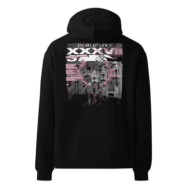 Back view of an oversized hoodie in black. A large rectangular back graphic layers an ornate hall interior in high-contrast greyscale beneath oversized roman numerals 'XXXVII' and a serif 'IN SILENTIO' wordmark. Dusty pink text bars carry a short poem down the left edge, cut through by thorned starburst linework in the same pink.