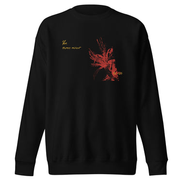 Front view of a solid-colored sweatshirt. A graphic on the chest features a large, abstract, high-contrast shape resembling a flower, accompanied by several lines of handwritten-style script.