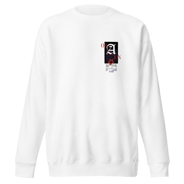 Front view of a solid-colored sweatshirt. A small, vertical collage graphic on the left chest features a large, high-contrast gothic letter 'A' layered with multiple small blocks of text and a floral illustration.