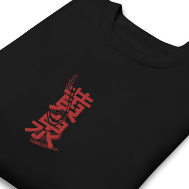 A solid-colored sweatshirt, neatly folded. An embroidered graphic is centered on the chest, featuring two large East Asian characters stacked vertically and rendered with a high-contrast, sketchy texture.