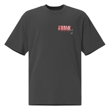 A faded black oversized tee with an off centered graphic to the left side of the sweatshirt. The design features the word 'THYME' in a large, white font layered over a red rectangle accompanied by red text depicting "FIELD" underneath it.