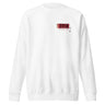 A white crewneck sweatshirt with an off centered graphic to the left side of the sweatshirt. The design features the word 'THYME' in a large, black font layered over a red rectangle accompanied by red text depicting "FIELD" underneath it.