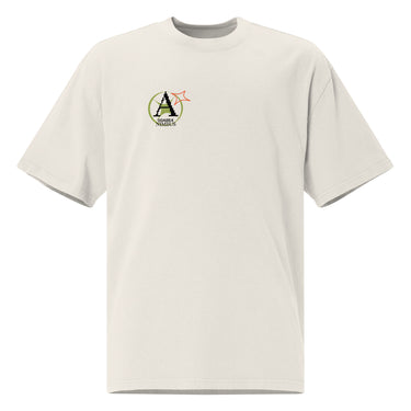 Front view of a solid-colored oversized-tee. A small graphic on the left chest features a circular emblem containing a large, pixel-art style letter 'A'. A small, outlined star symbol is next to the emblem.