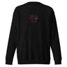 Front view of a solid-colored, sweatshirt. A small graphic is centered on the chest, featuring a circular emblem made of three swirling shapes, rendered with a high-contrast, distressed texture.