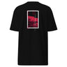 Back view of a solid-colored shirt. A large, vertical graphic on the upper back is framed by a high-contrast border. Inside the frame is a high-contrast illustration of spider lily flowers, with several small blocks of text layered over the image.