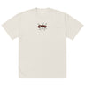 Front view of a solid-colored, oversized-tee. A small graphic is centered on the chest, featuring the word "Caesar" in a stylized script font, layered over a background of sketchy, crisscrossing lines.