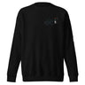 Front view of a solid-colored sweatshirt. A small graphic on the left chest features a geometric, flower-like symbol made of fine lines, next to a vertical block of technical-style text.
