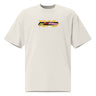 Front view of a solid-colored oversized-tee. A small, horizontal graphic on the chest features the stylized text "NC DEMARA" filled with a high-contrast, diagonal stripe pattern.