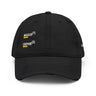 Black distressed baseball cap, front view, showing embroidered white text 'MAGUS(1)' and 'ORPHIE(2)' stacked vertically with bold yellow underlines, visible distressed details on brim and panels.