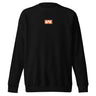 Black sweatshirt, front view, featuring a small centered orange rectangular logo with a stylized white 'M' inside.