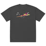 Front view of a solid-colored oversized-tee. A large, dynamic graphic across the chest features a chaotic collage of high-contrast brush strokes, sharp angular forms, and silhouettes resembling swooping birds.