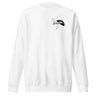 Front view of a solid-colored, sweatshirt. A small graphic on the left chest features a fine-line illustration of a winged creature, layered with the word "premonition" in a high-contrast, distorted font.