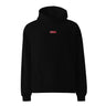 Front view of an oversized hoodie in black. Design is a small, embroidered red patch on the left chest featuring the white line art of an Astral Express ticket from Honkai: Star Rail.