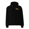 Front view of an oversized hoodie in black. Design is positioned on the upper left chest. Design features a yellow rectangular label reading “CONNECKEN,” smaller text “DER WÄCHTER,” and fine white script lines and coordinates below it.