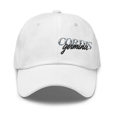 Front view of an baseball cap in white. Design is with embroidered text centered above the brim. The stitching combines serif and script styles, reading “Cordis Germina.”