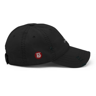 Side view of an distressed hat in black. Evernight inspired design features an embroidered red circular patch on the side featuring a stylized character. Adjustable strap with metal clasp visible at the back.