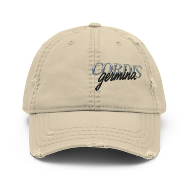 Front view of an distressed hat in white. Design is with embroidered text centered above the brim. The stitching combines serif and script styles, reading “Cordis Germina.”