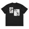 Back view of a box tee in black. A large two-panel composition fills the back. On the left, a halftoned portrait with a solid black bar across the eyes; to the right, a wider panel of sweeping feathers in heavy contrast. The words "pas" and "d'aveu" float above them in a fine serif, the letters spaced apart and drifting.