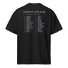 Back view of a box tee in black. A large graphic fills the upper back, laid out like a concert tour poster. A wide display serif title reads "VARIATIONS OF A STELLAR TOUR" in white, with a small italic "robin" and "/summeretto" tucked beneath it and a ruled row of four era markers below that. Two columns of dated stops run down the rest in condensed capitals, the dates set in violet, with thin outlined starbursts drifting across the list.
